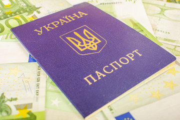 Ukrainian passport against the background of Euro-accounts with a face value of 100