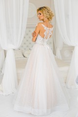 A bride with hairstyle and make up in gougeous wedding dress preparing for the wedding. A portrait...