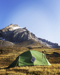 The tent is on top of the mountain. The solar panel hangs on the tent.