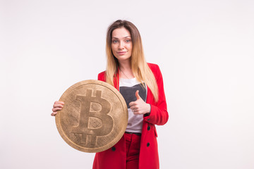 Freckled woman holding big bitcoin on white background. Cryptocurrency investment concept.