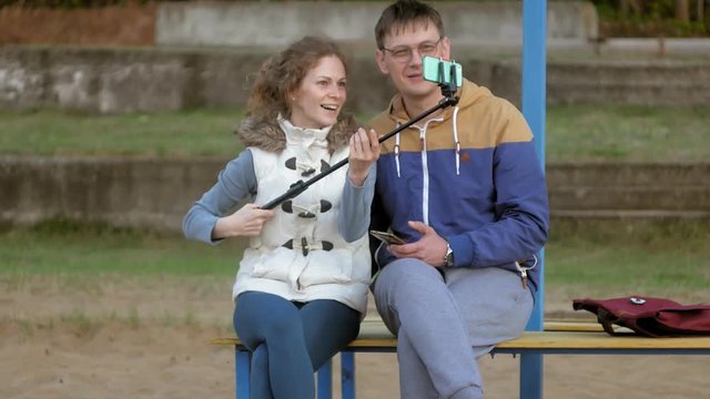 man fnd woman smile take self picture selfie with smart phone mobile on the park