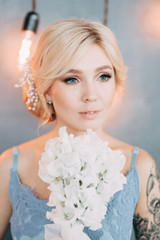Naklejka premium Beautiful bride in front of wedding arch with flowers and decor. Bouquet in the hands and details. The girl is happy, smiling and dancing. Dream wedding dress in modern style