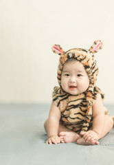 Soft focus Cute Asian male baby sitting on a towel. Blurred background.