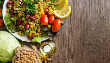 Healthy food background ,fruits and vegetables with salad bowl on wooden table.