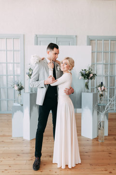 Beautiful wedding in European style, in light blue colors. Couple in the Studio on the background of an unusual arch, inspiration. Laughing bride and handsome groom