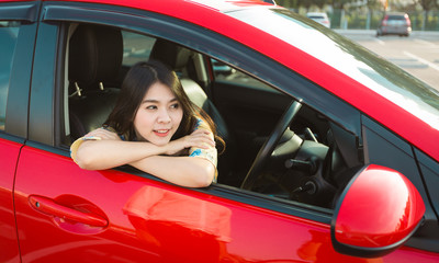 Beautiful asian woman enjoying life  in the red car.