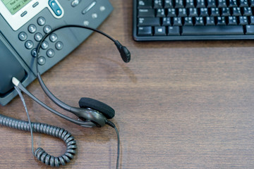 close up headset earphone on wooden desk table for call center occupation concept.	