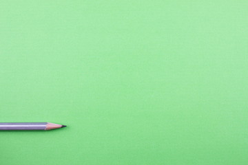 Pencil on green tone color paper. Empty space for text and design. Minimalism concept.