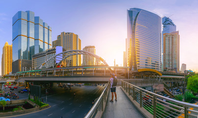 high modern building cityscape central city at golden hour with sunlight and traffic car on the road at night with photographer shooting high-rise building.