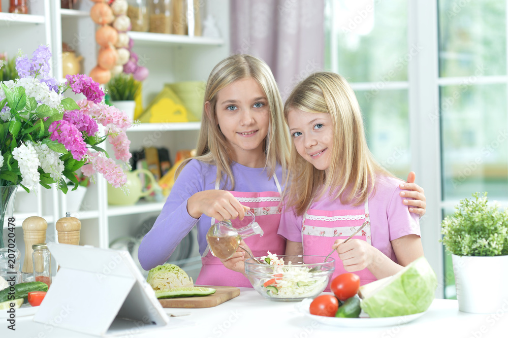 Wall mural two girls in aprons preparing fresh salad