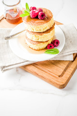 Trendy asian food, Fluffy Japan souffle pancakes, hotcakes with maple syrup and raspberry light concrete background copy space