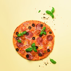 Delicious italian pizza, basil leaves, salt, pepper on yellow background with copyspace. Square crop. Top view. Banner. Pattern for minimal style. Pop art design, creative concept