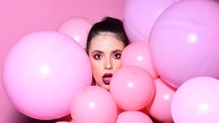 Fototapeta na wymiar Balloon party on pink studio background. Retro girl with stylish makeup and hair. Birthday decor and celebration. girl dreaming in punchy pastels trend. Fashion woman with many pink air balloons