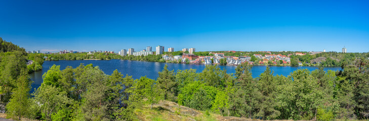 A panorama of the Jaerla lake and the Jaerla area in Nacka municipality and some buildings in Stockholm city furthest away in the background