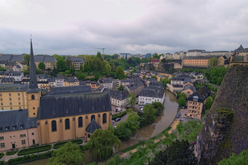 Beautiful skyline of old town Luxembourg City from top view in Luxembourg. Abbaye St. John Neimenster near Alzette River at spring cloudy day. Luxembourg, Grand Duchy of Luxembourg