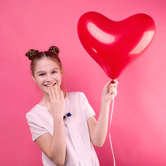 Girl on a pink background with a red balloon in the shape of a heart