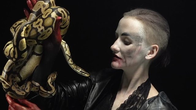 Woman in image holding two pythons