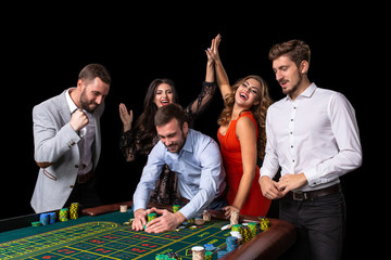 Adult group celebrating friend winning at roulette