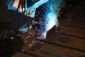 Welder at work for close-up work, joining parts with welding.