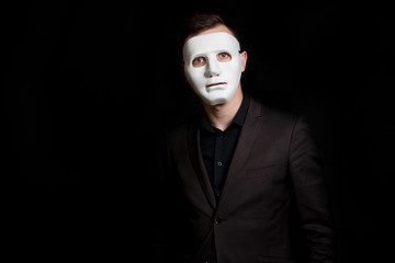 A man in a white mask on a black background.