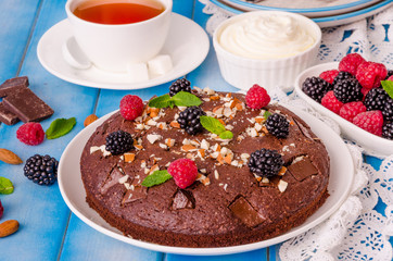 Chocolate cake brownie with raspberries, blackberries, almonds and whipped cream