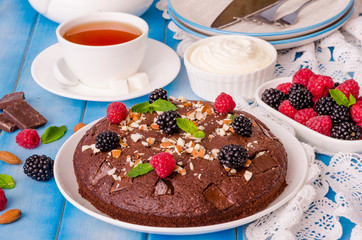 Chocolate cake brownie with raspberries, blackberries, almonds and whipped cream