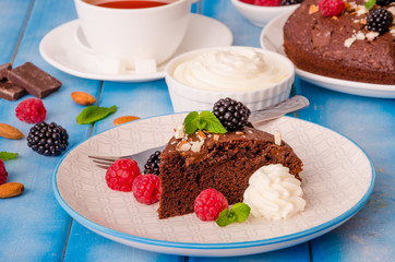 Chocolate cake brownie with raspberries, blackberries, almonds and whipped cream