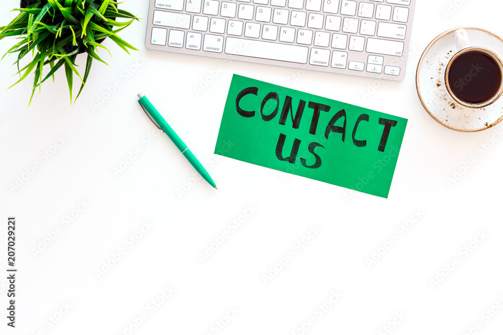 Poster frame contact us. lettering contact us on office work desk with computer on white background top vie