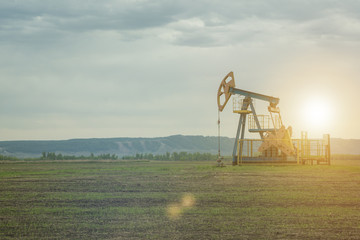 oil pump, production. against the background of the sky of the mountains.