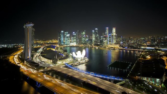 Elevated illuminated downward view over the City Centre and Marina Bay, South East Asia, Time lapse
