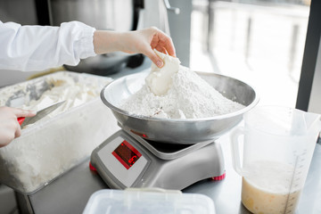 Weighing flour for baking with professional scales at the manufacturing, close-up view