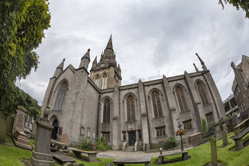 Fototapeta premium Fisheye view of graves and the Kirk of Saint Nicholas Uniting in Aberdeen, Scotland.