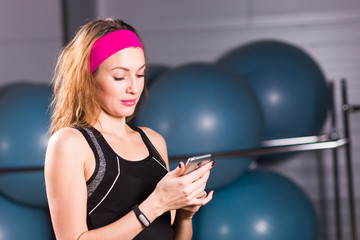 Sporty young woman with fitness tracker in gym