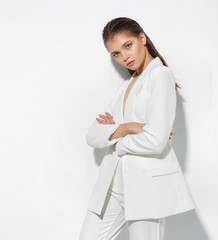 Young woman on a white wall background. High fashion