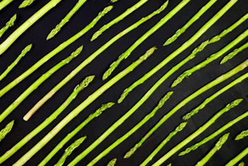 Fresh green asparagus pattern, top view. Isolated over black. Food background asparagus flat lay pattern