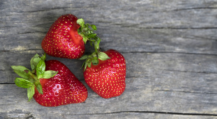 Ripe strawberries over wooden table background with copy space