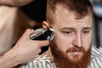 Fototapeta na wymiar Barber and bearded man in barber shop