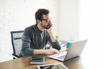 Fototapeta premium Man busy using laptop at home office