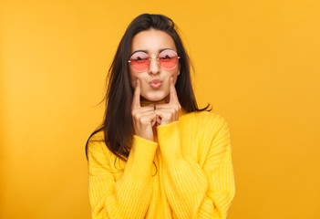 Woman in sunglasses touching cheeks