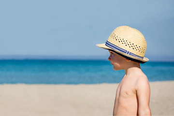 Fototapeta na wymiar Little cute boy in hat on the sea background.