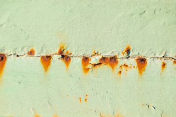 Irradiated green paint on rusty iron closeup