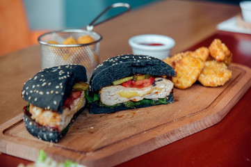 cutted black burger served with chicken nuggets and cheese balls