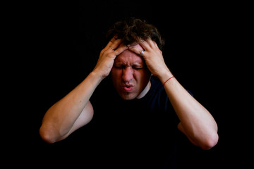 Stress. A man holds his head with his hands. 