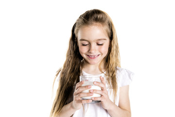 Portrait of a cute 7 years old girl Isolated over white background with milk glass