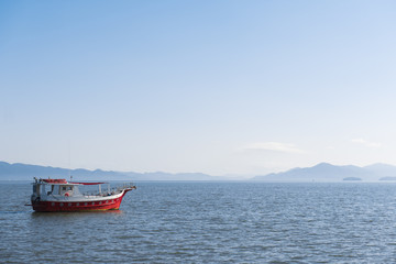 Obraz premium Red boat in blue sea, Beira Mar Norte, Florianópolis, Santa Catarina, Brazil