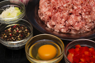 Raw meat beef in a plate with spices on a black cutting board. Fresh stuffing.