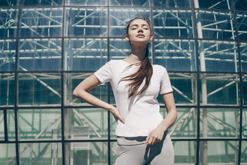 Fototapeta premium confident slender girl resting after a workout outdoors, tired doing exercises