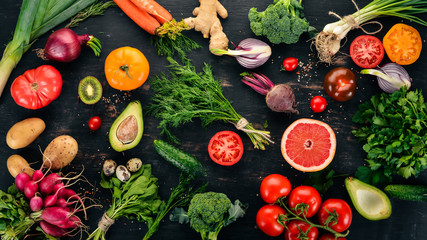 Healthy food. Vegetables and fruits. On a black wooden background. Top view. Copy space. - obrazy, fototapety, plakaty