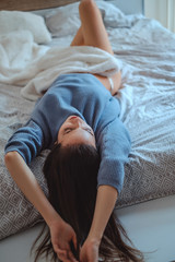 Brunette lying on the bed upside down