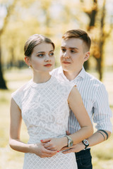 Obraz premium Beautiful young couple in the Park on a Sunny day, loving and happy. Walk and laugh together. Pre-wedding shooting in nature. Elegant style in clothes like celebrities
